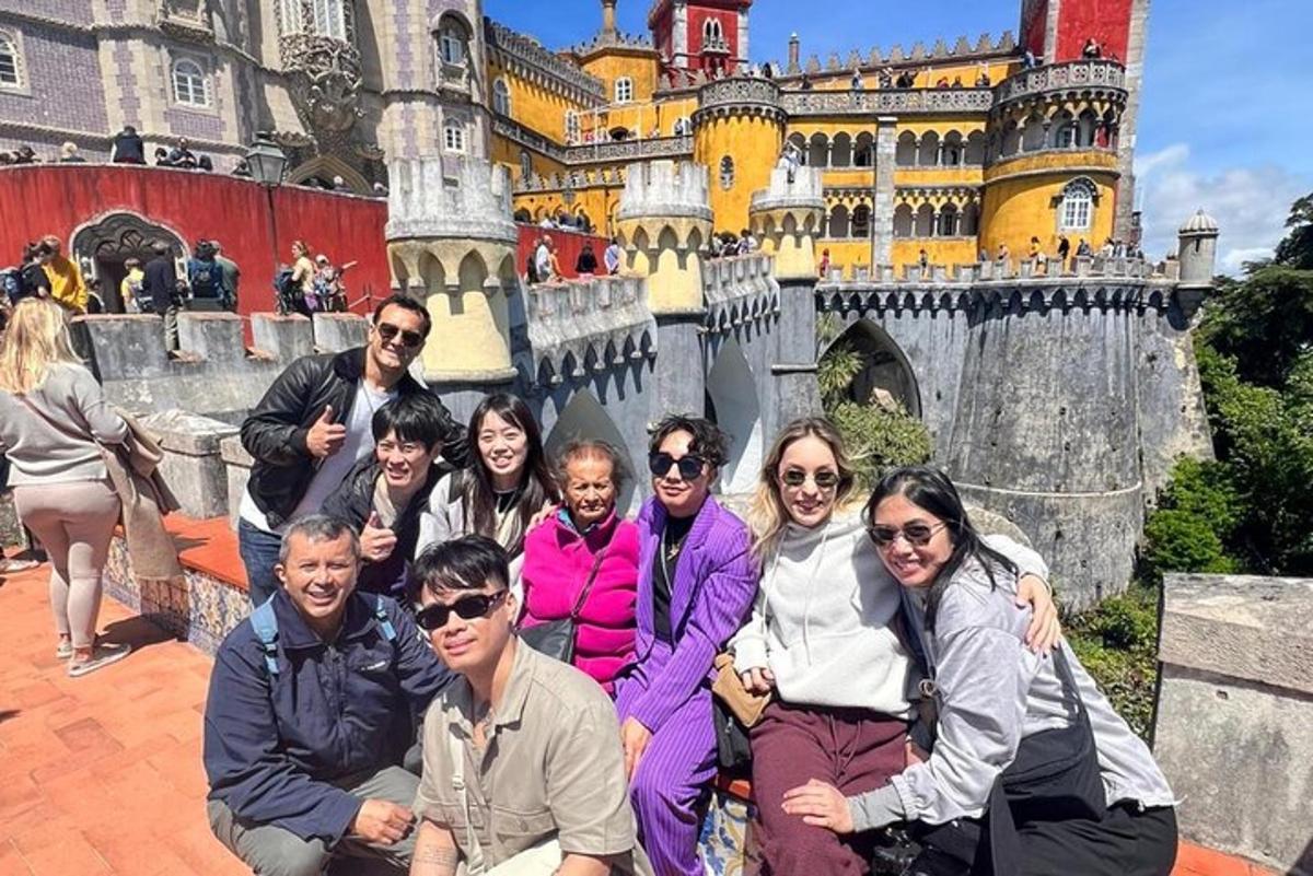 a group of people posing in front of a castle