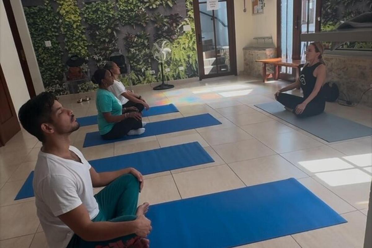 un grup de oameni așezați pe podea la o clasă de yoga