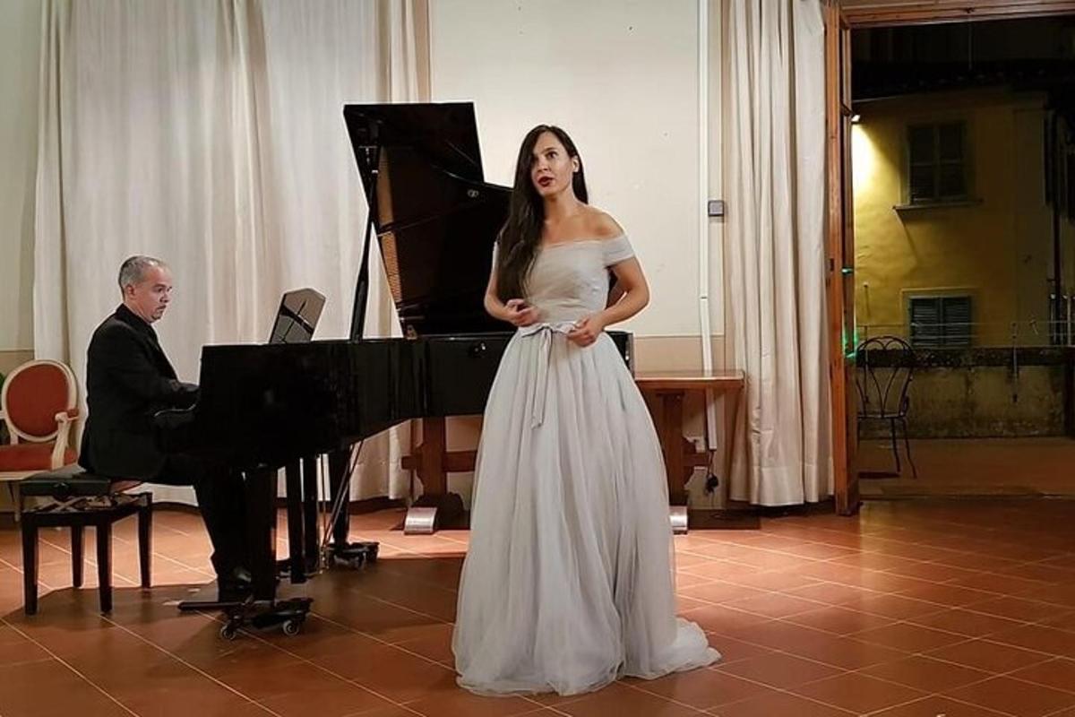 žena v bílých šatech stojící vedle klavíru