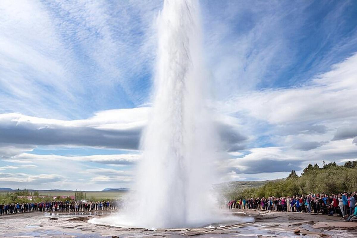 a crowd of people standing around a geyser