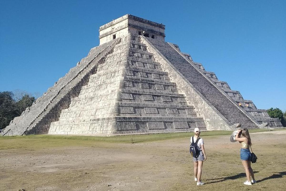 two people standing in front of a pyramid