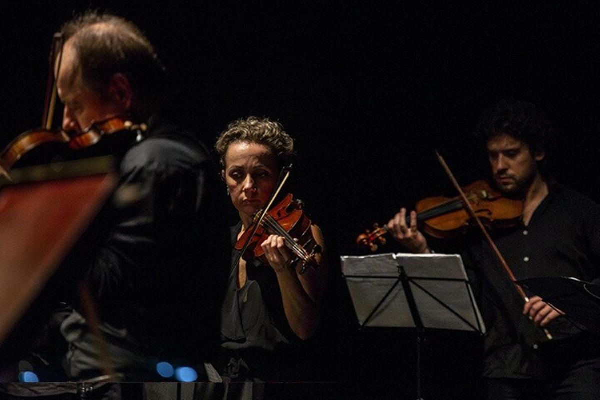 um grupo de pessoas tocando violinos e uma orquestra