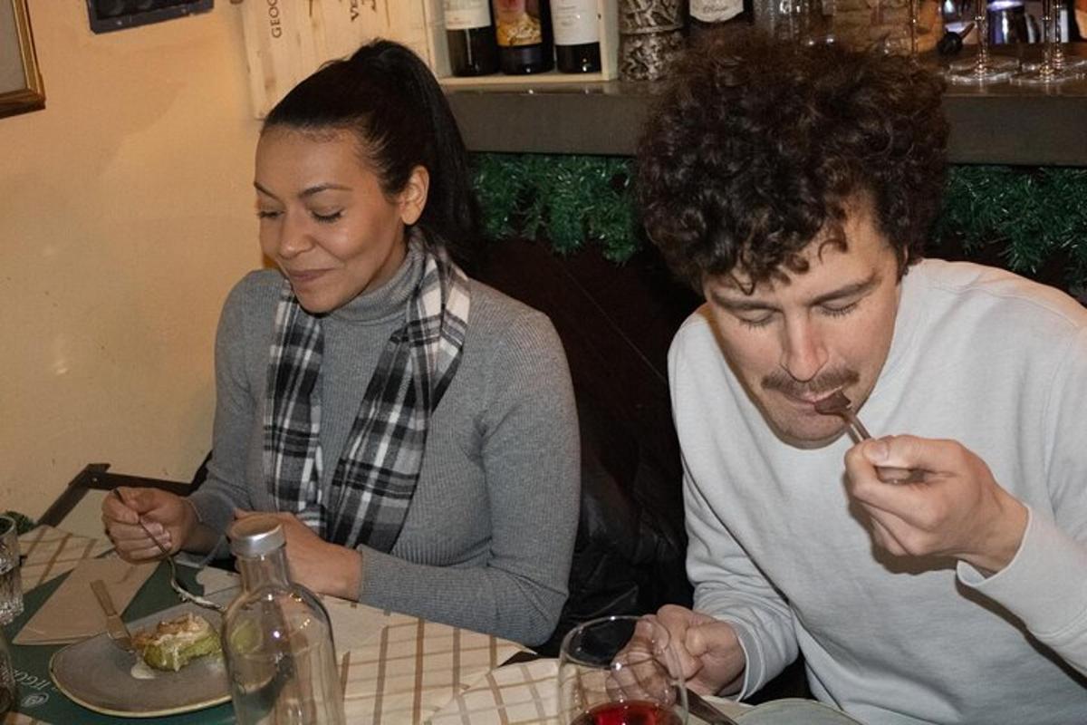 muž a žena sedia za stolom a jedia jedlo