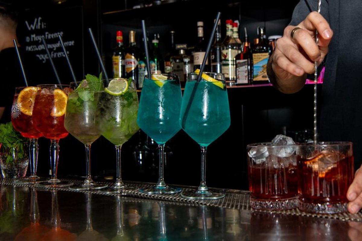 deretan koktel berwarna berbeza di bar