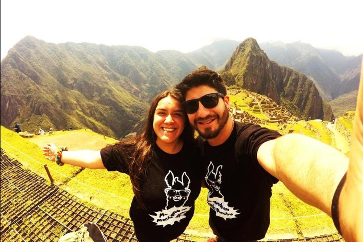 un uomo e una donna in posa in cima a una montagna
