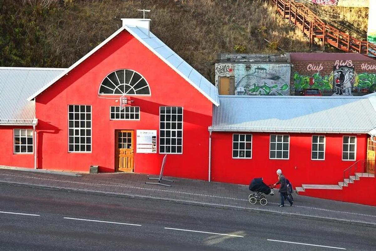 um prédio vermelho com duas pessoas caminhando na frente dele