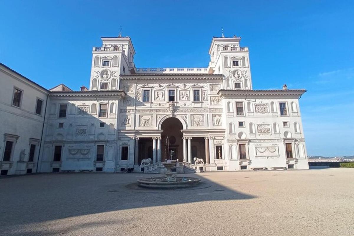 ein großes weißes Gebäude mit einem Brunnen davor