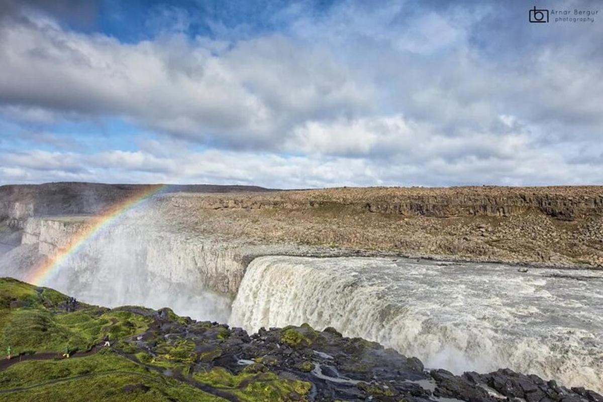 een regenboog aan de rand van een waterval