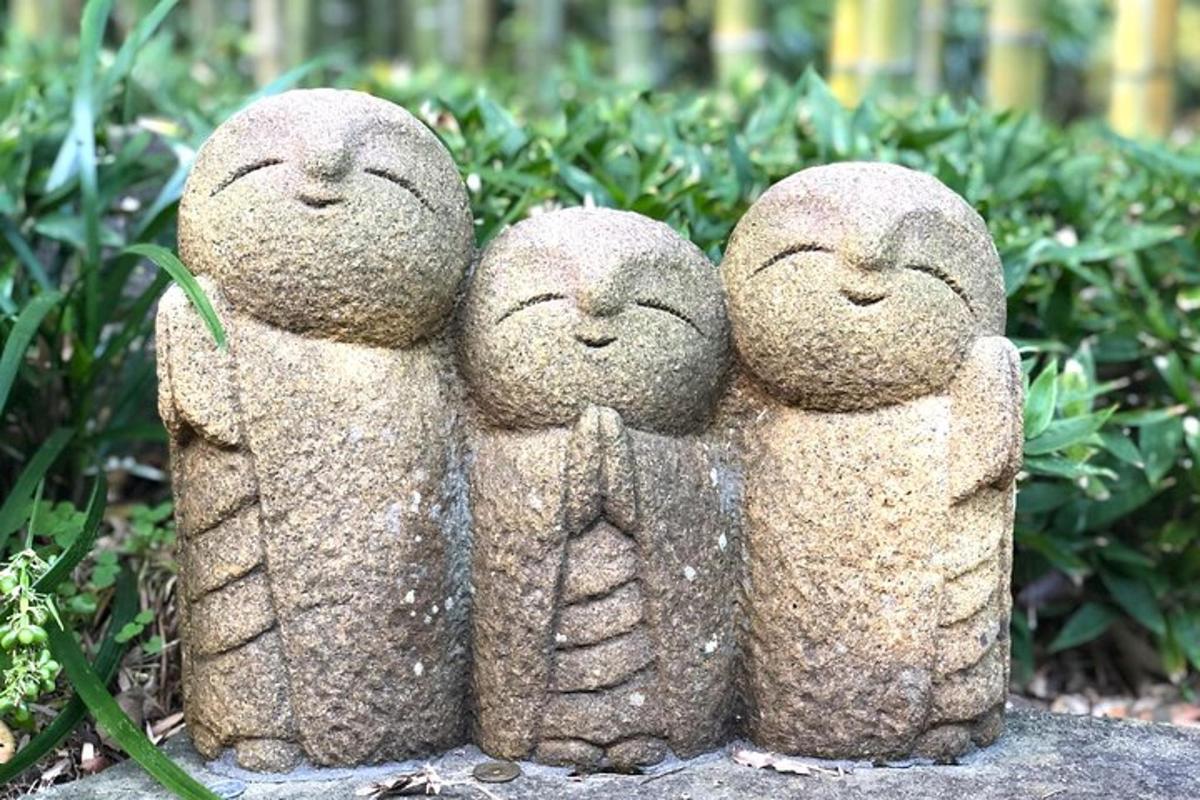 tre statuer af tre personer, der sidder ved siden af hinanden