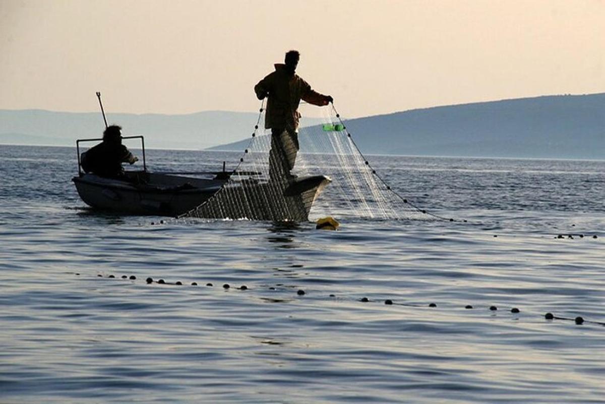 a man is standing on a boat with a net