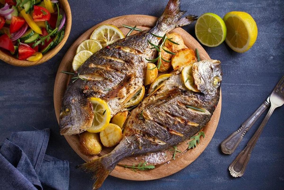 a plate of fish and potatoes and a bowl of vegetables