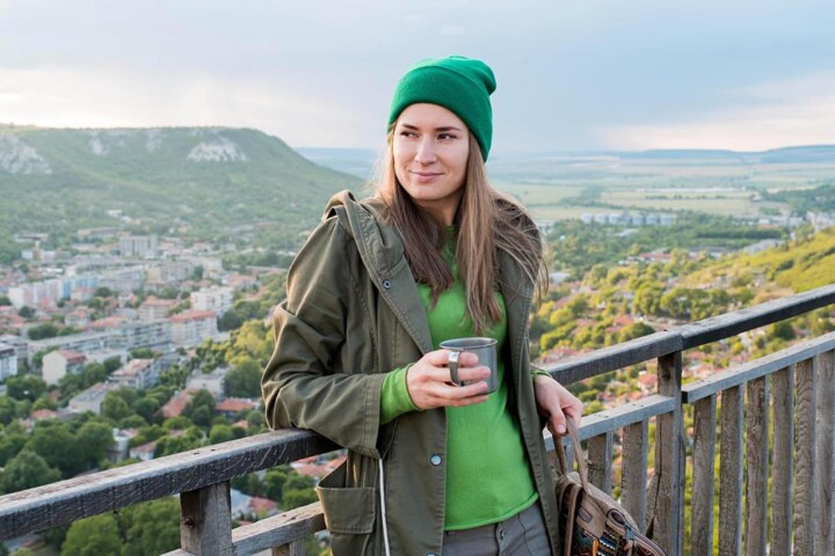 a woman standing on a railing holding a coffee cup