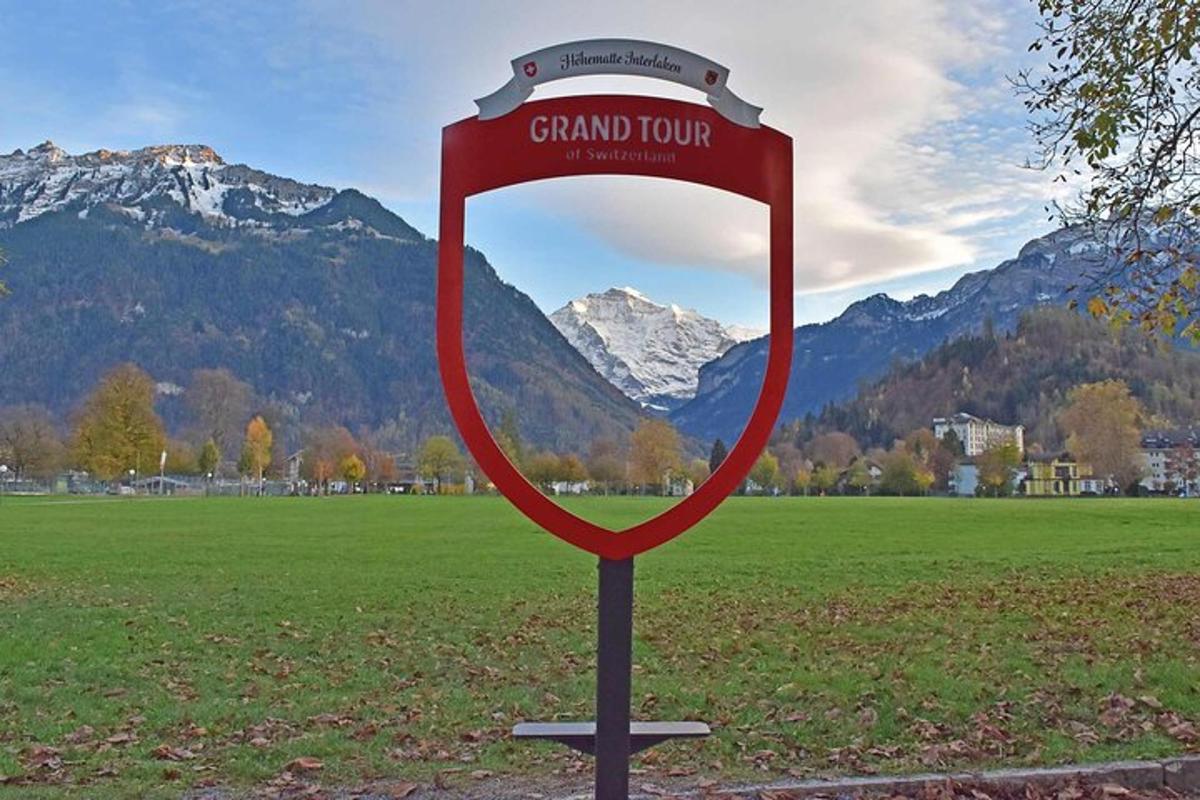 ein riesiges Schild auf einem Feld mit Bergen im Hintergrund