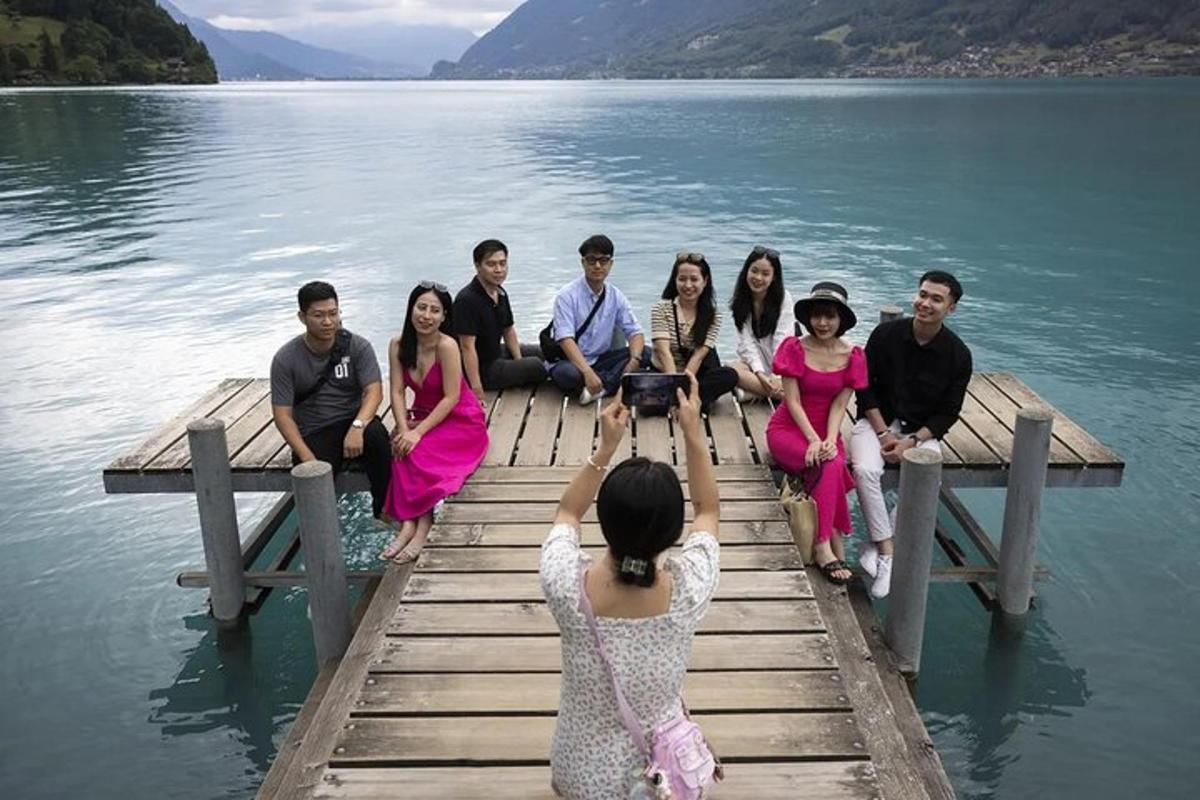 eine Frau, die ein Foto von einer Gruppe von Menschen auf einem Dock macht