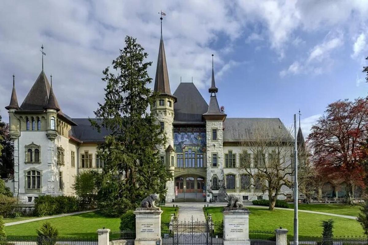 ein großes weißes Gebäude mit einem Baum davor