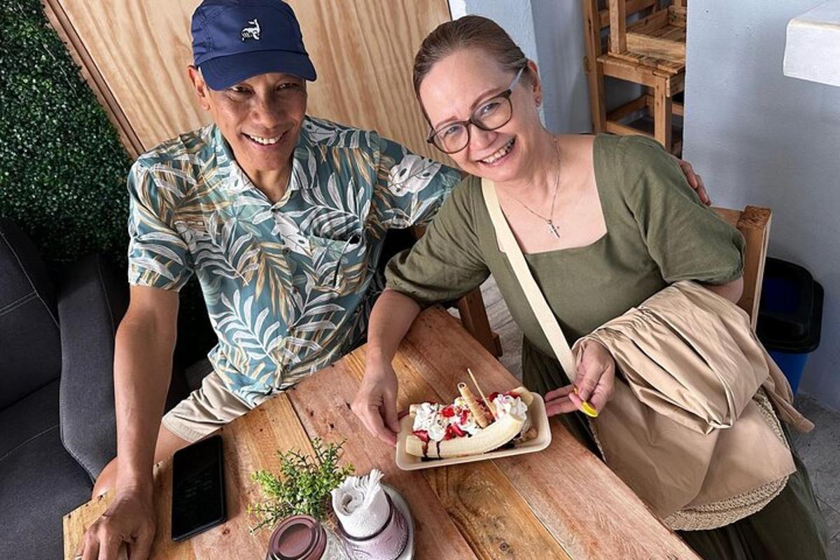 a man and a woman sitting at a table with a plate of food