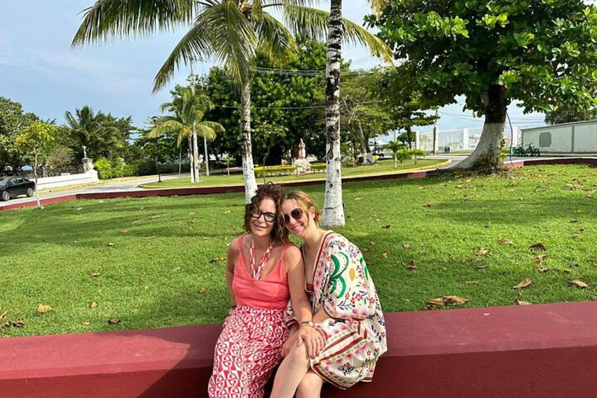 two women sitting on a bench in a park
