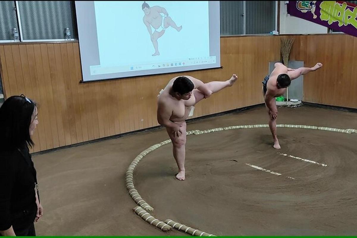 dois homens em um ringue de luta livre em uma academia