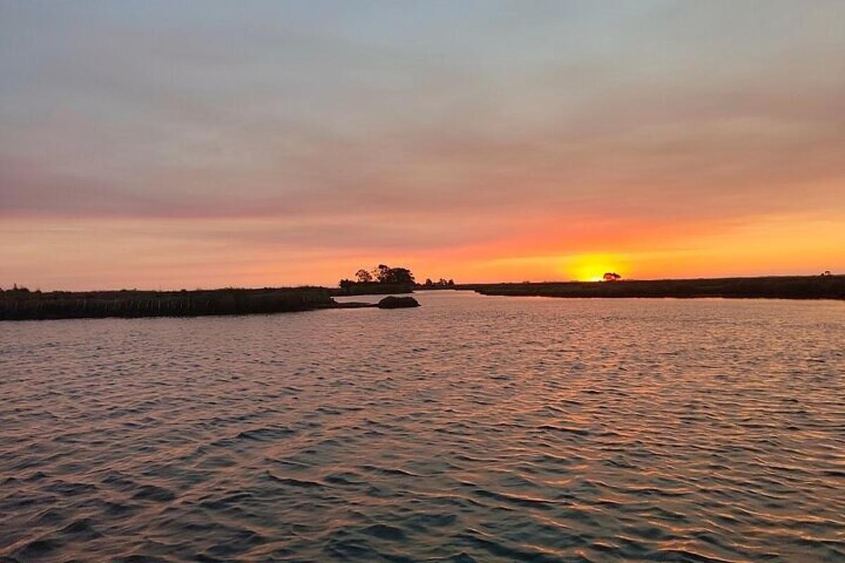 una posta de sol sobre una massa d'aigua amb la posta de sol