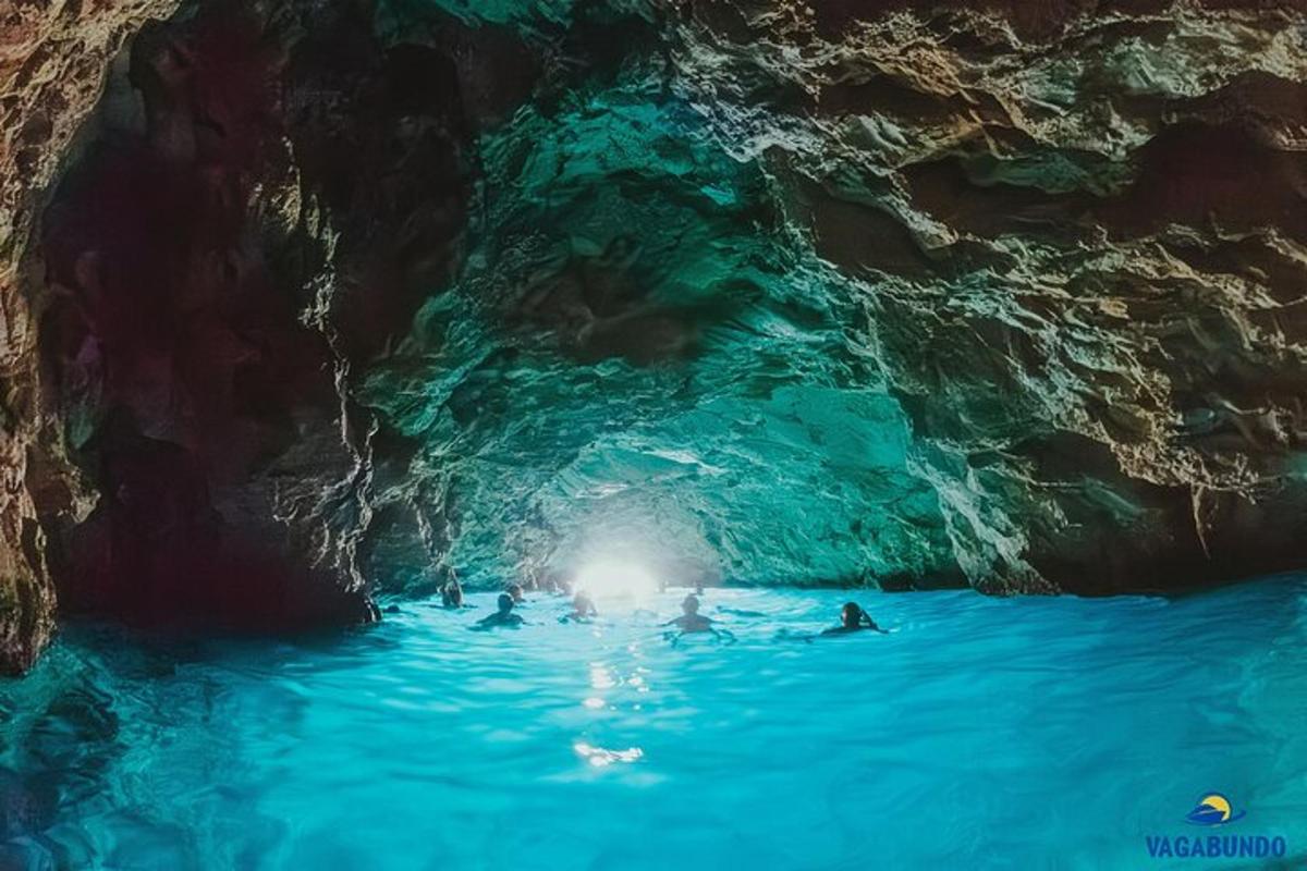 Un grupo de personas nadando en una cueva azul.