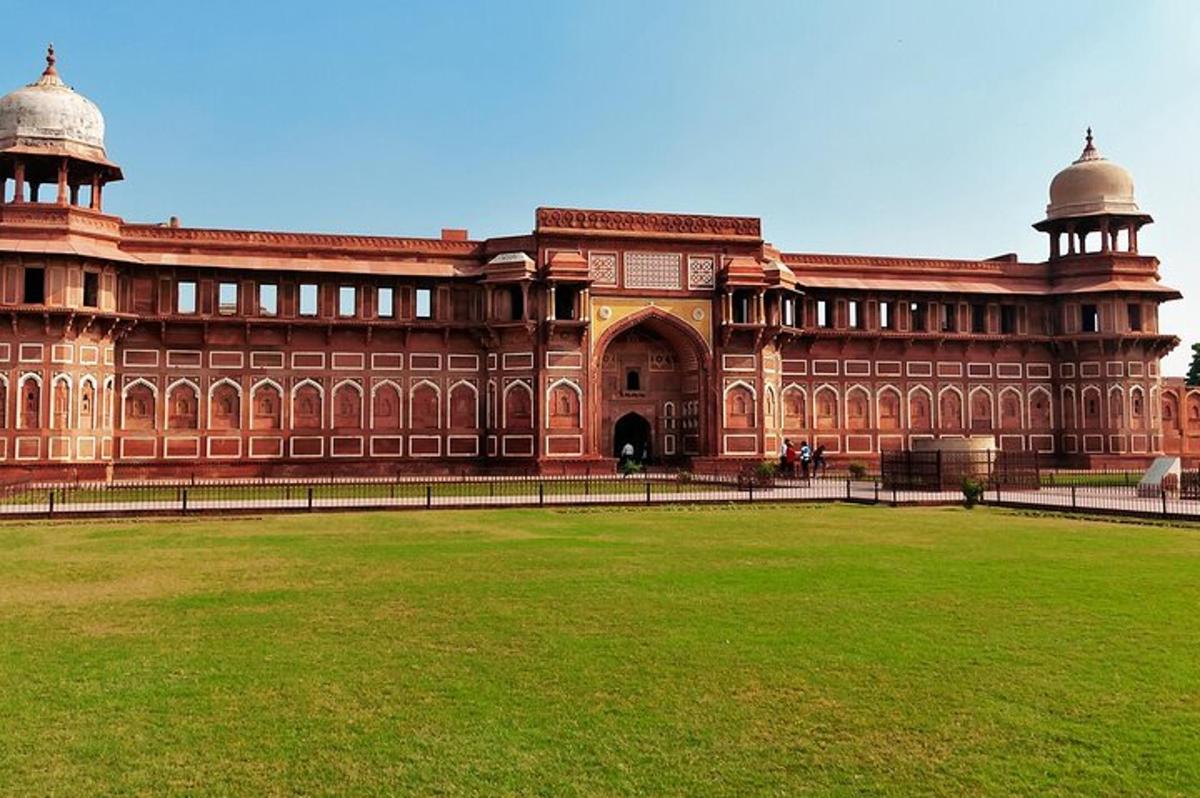 a large building with a green field in front of it