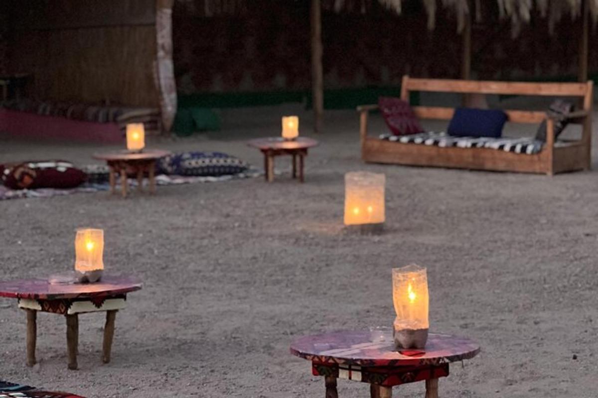 a group of candles sitting on tables in the sand