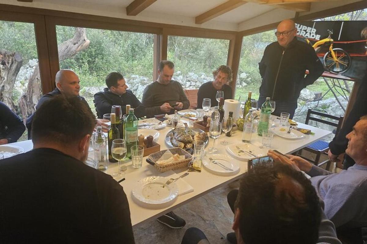 een groep mensen die rond een tafel zitten