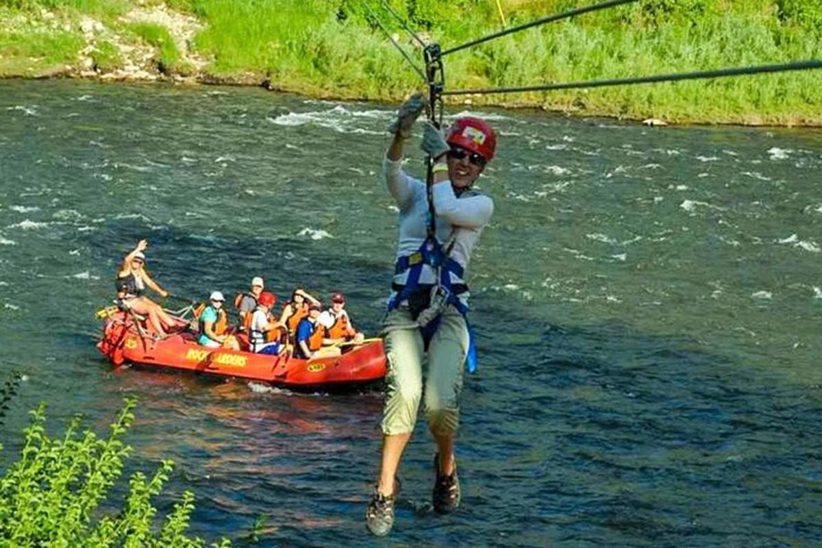 osoba držící se lana při jízdě na voru na řece