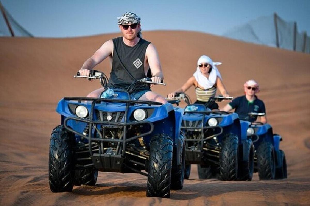 dois homens andando de quadriciclo no deserto