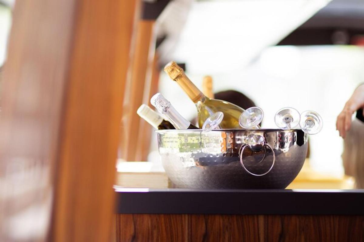 a bucket of wine bottles and glasses on a table