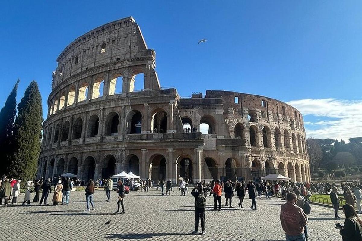 un gruppo di persone in piedi davanti al Colosseo