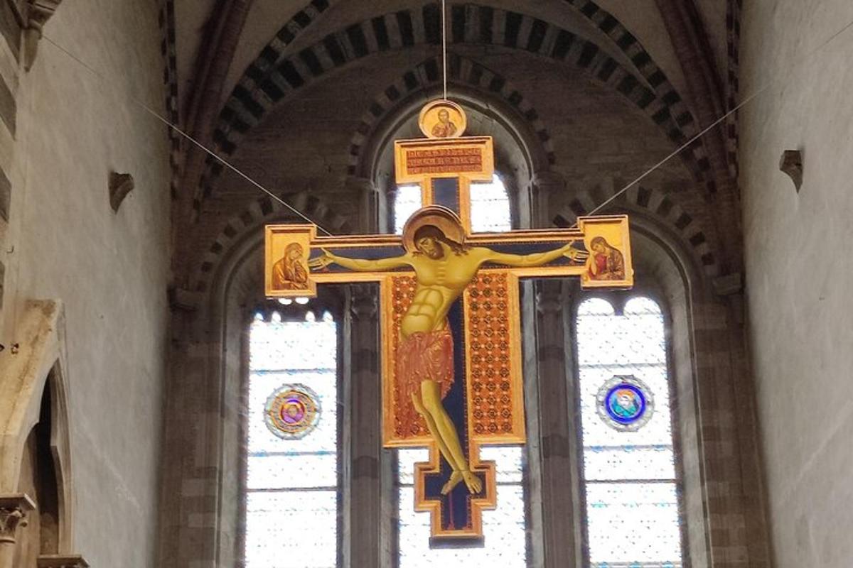 a cross hanging in a church with windows
