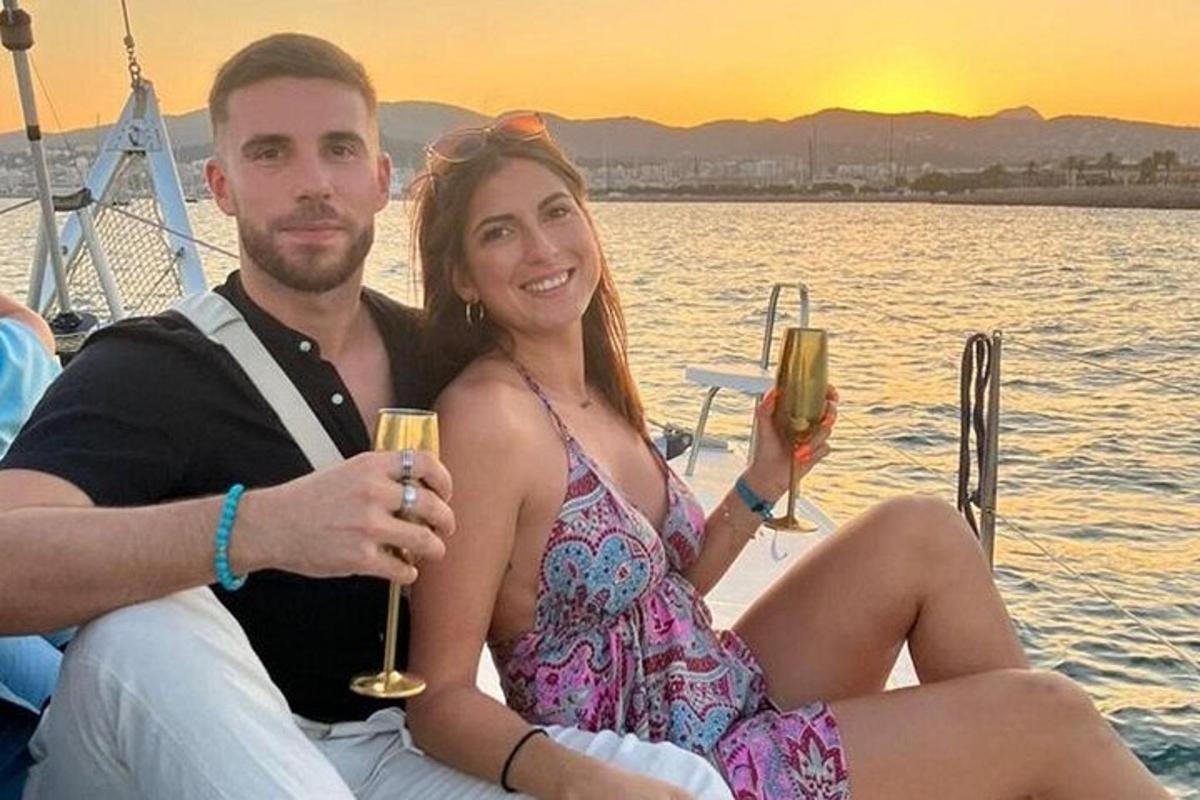 um homem e uma mulher sentados em um barco com taças de vinho