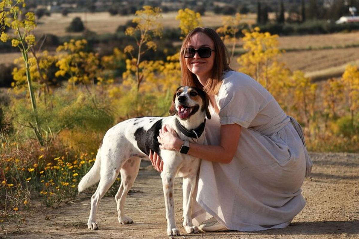 žena klečící na prašné cestě se psem