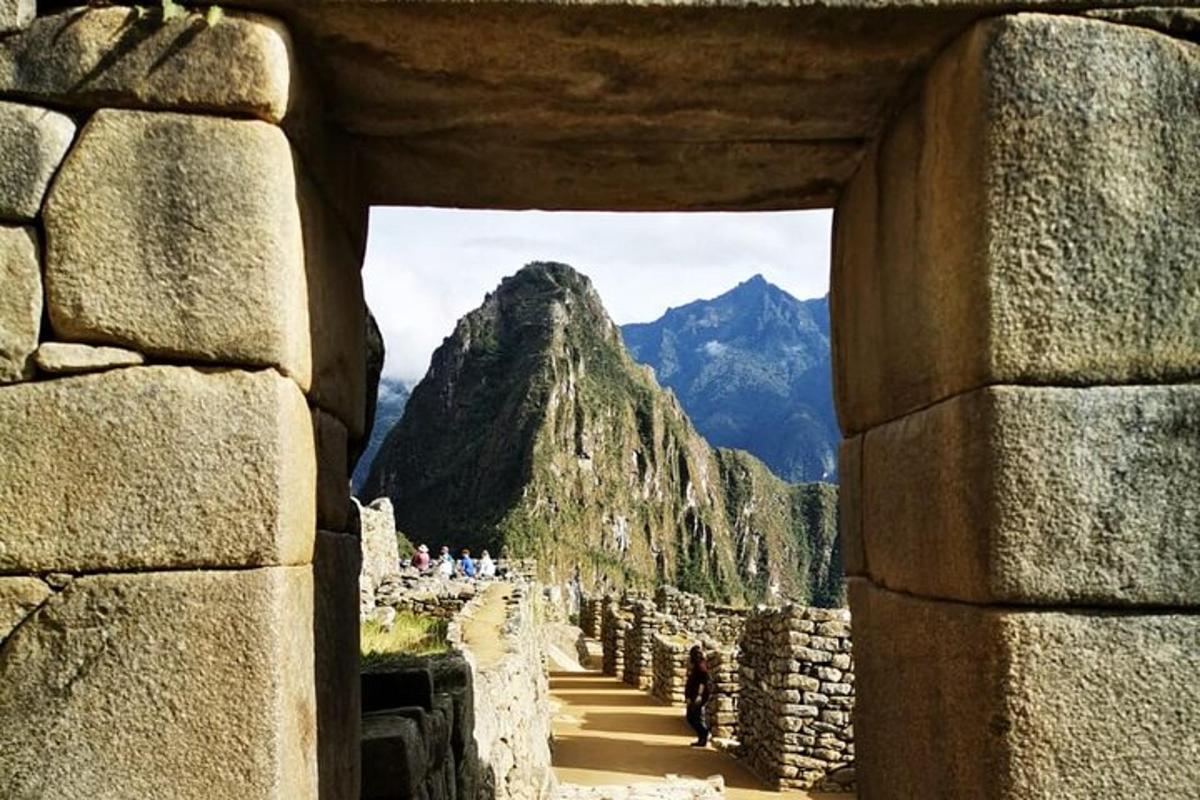 una vista di una montagna attraverso un muro di pietra