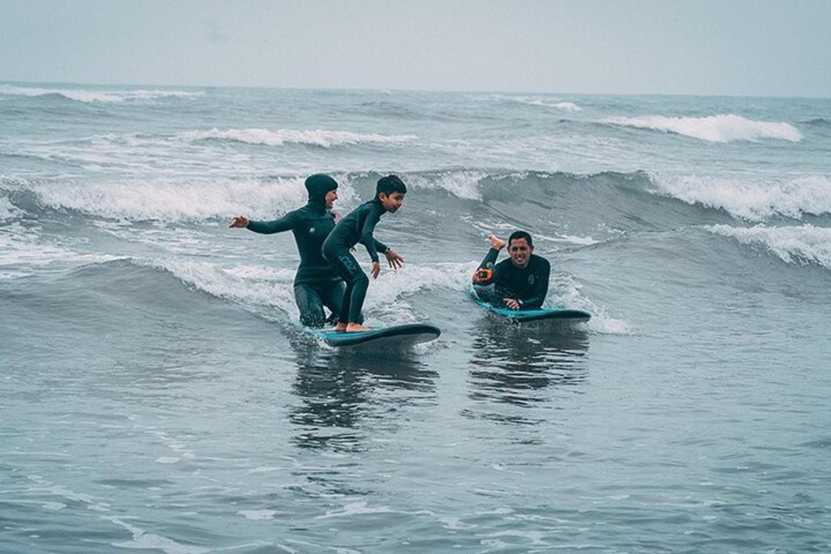 Tres personas en el océano en tablas de surf en el océano