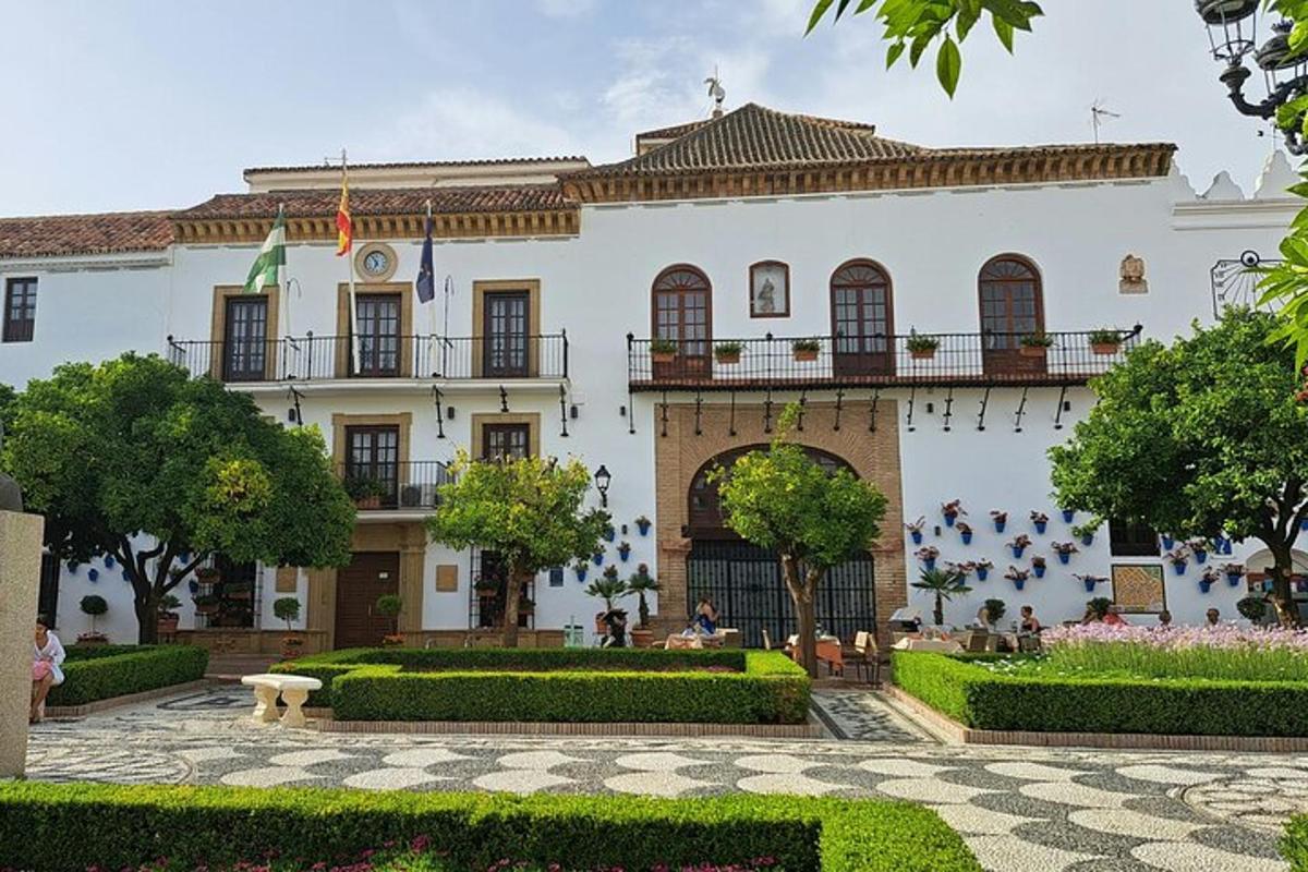 a large white building with a garden in front of it