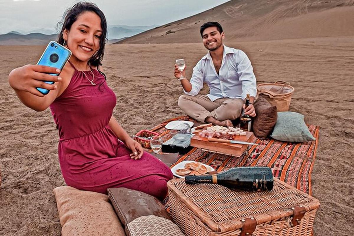 Un hombre y una mujer sentados en el desierto sosteniendo una copa de vino.
