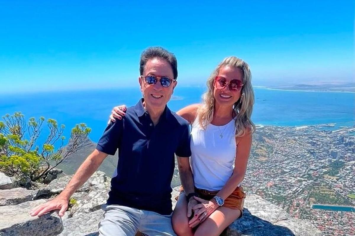 un uomo e una donna seduti in cima a una montagna