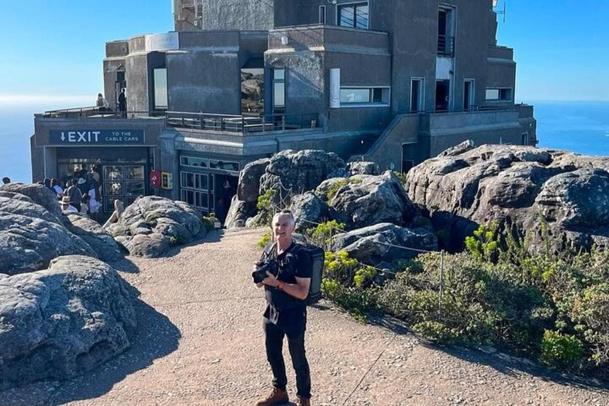 un uomo che tiene una macchina fotografica davanti a un edificio