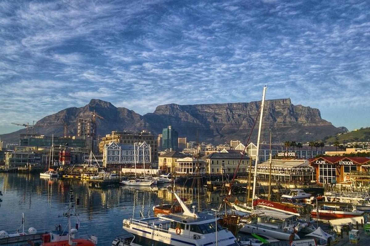 un gruppo di barche attraccate in un porto con una montagna sullo sfondo