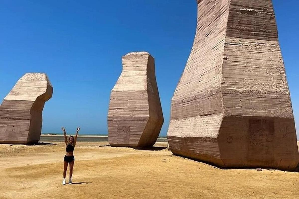 Una mujer parada frente a dos grandes torres de piedra