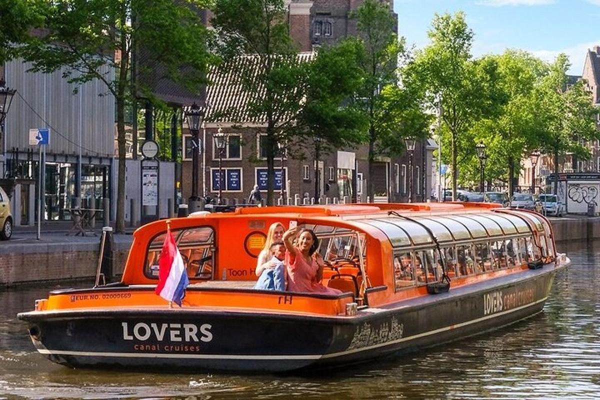 ein orangefarbenes Boot mit Menschen darauf auf einem Fluss