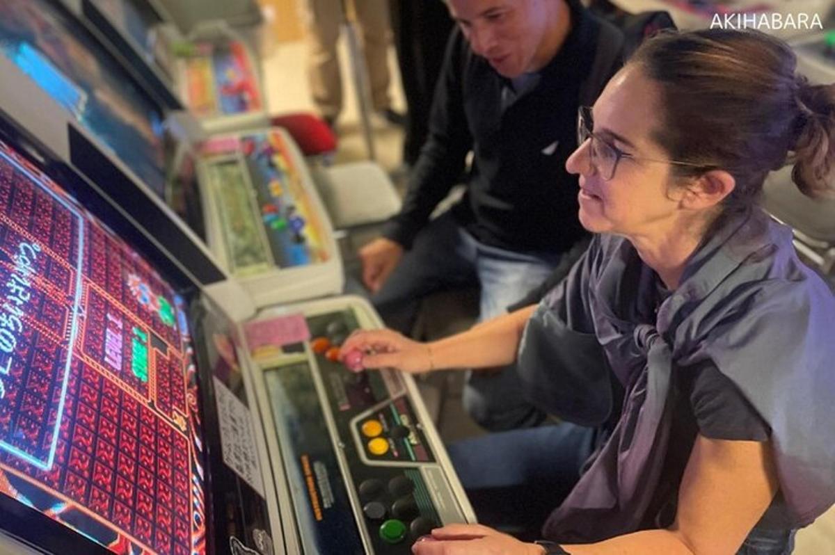žena hrající videohru na pinballovém automatu