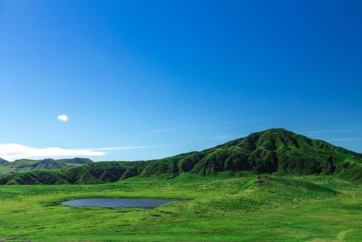 a mountain with a lake in the middle of a field