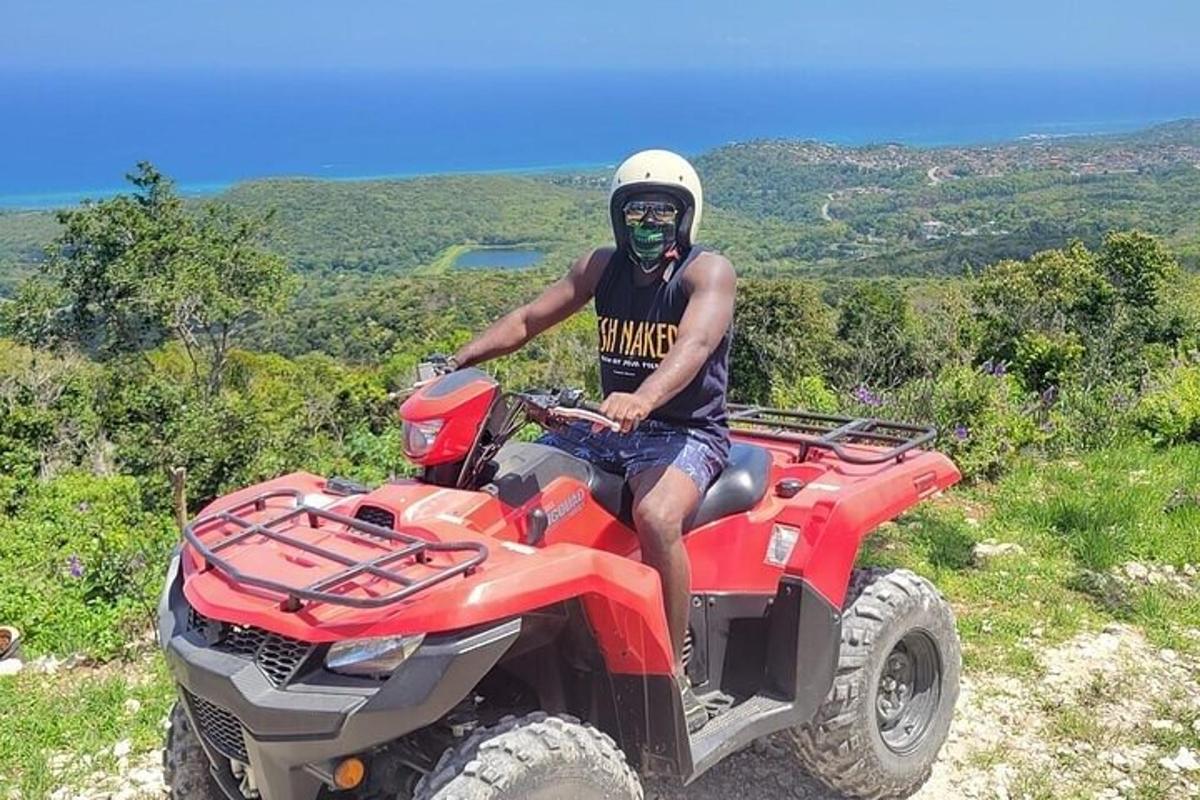 a man is sitting on a atv on a hill