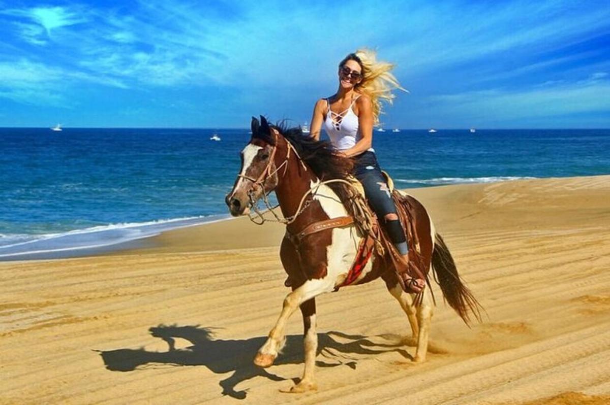 una donna a cavallo sulla spiaggia