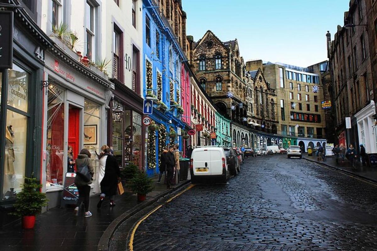 a city street with people walking down a cobblestone street