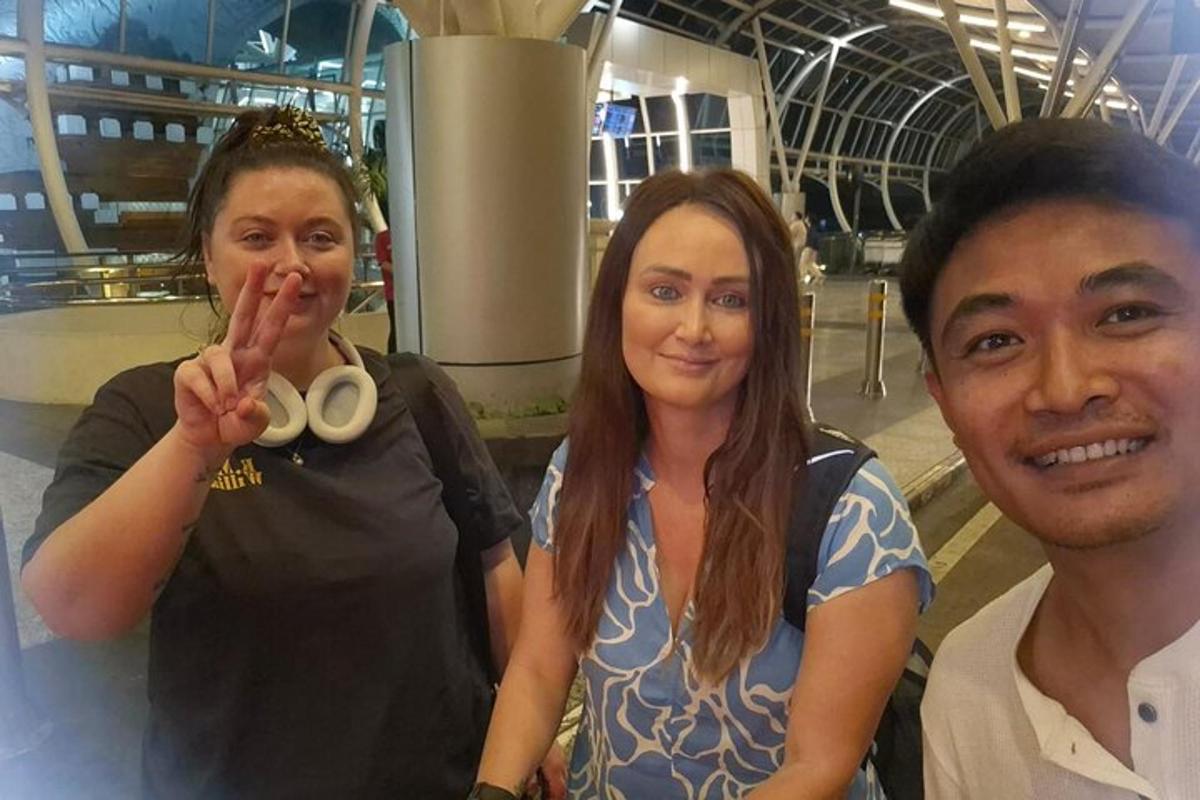 Dos mujeres y un hombre posando para una fotografía