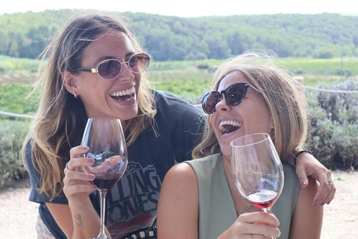 due donne sorridono mentre tengono in mano dei bicchieri di vino
